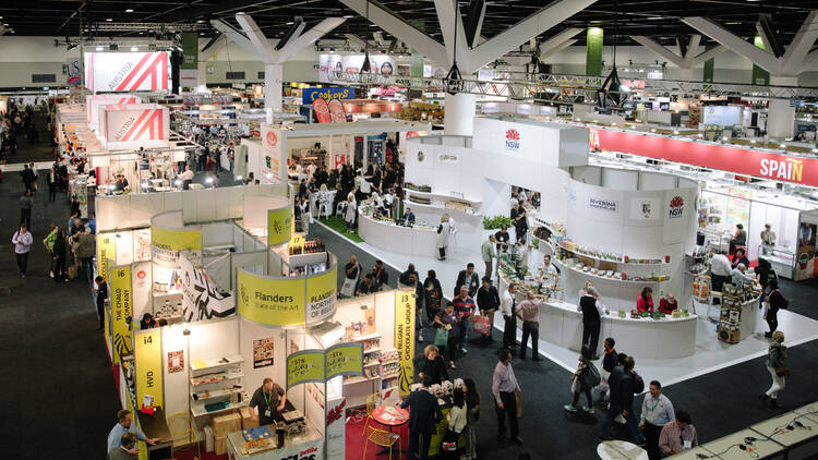 A wide, high-angled shot of a food-focused expo with lots of different stalls.