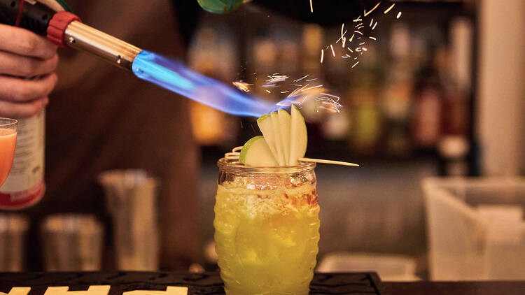 A cocktail garnish getting set on fire.