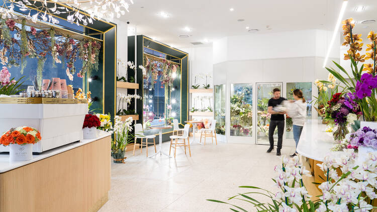 A light, bright florist with floral arrangements and a counter with a coffee machine.