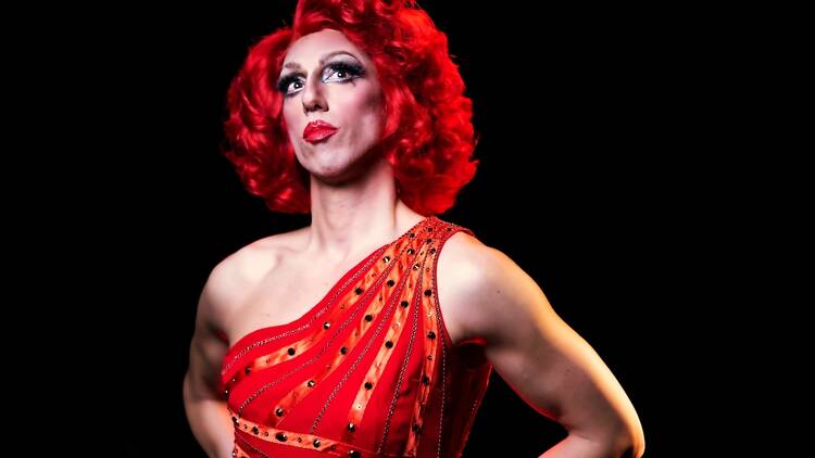 A drag performer with a red wig