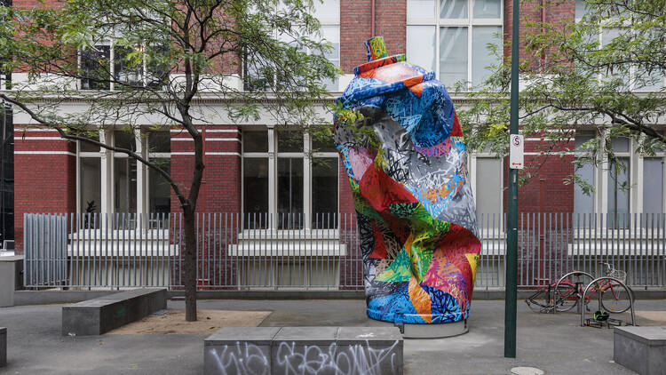 A sculpture of a giant spray can is decorated with multicoloured spray splashes of paint