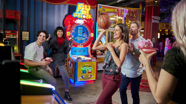 A group of friends playing arcade games. 