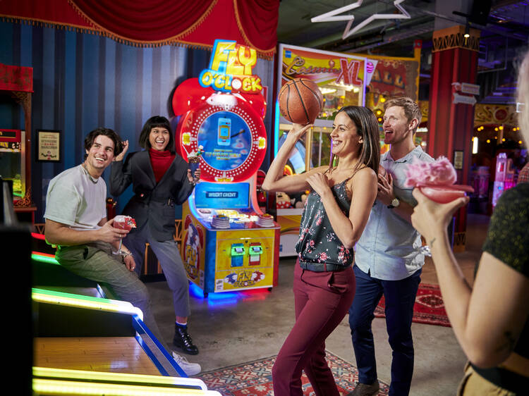 A group of friends playing arcade games. 