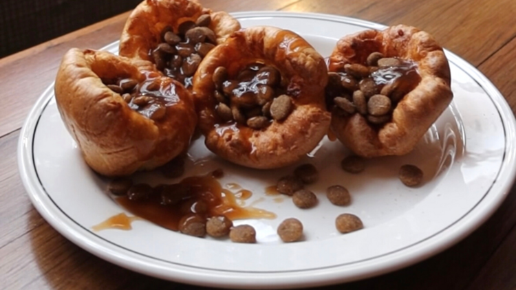 Four dog friendly tiny yorkshire puddings sit on a white plate 