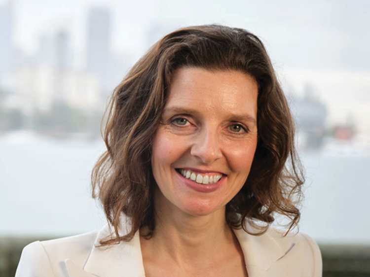 Allegra Spender, the independent member for Wentworth smiles in a headshot with the city and ocean in the background