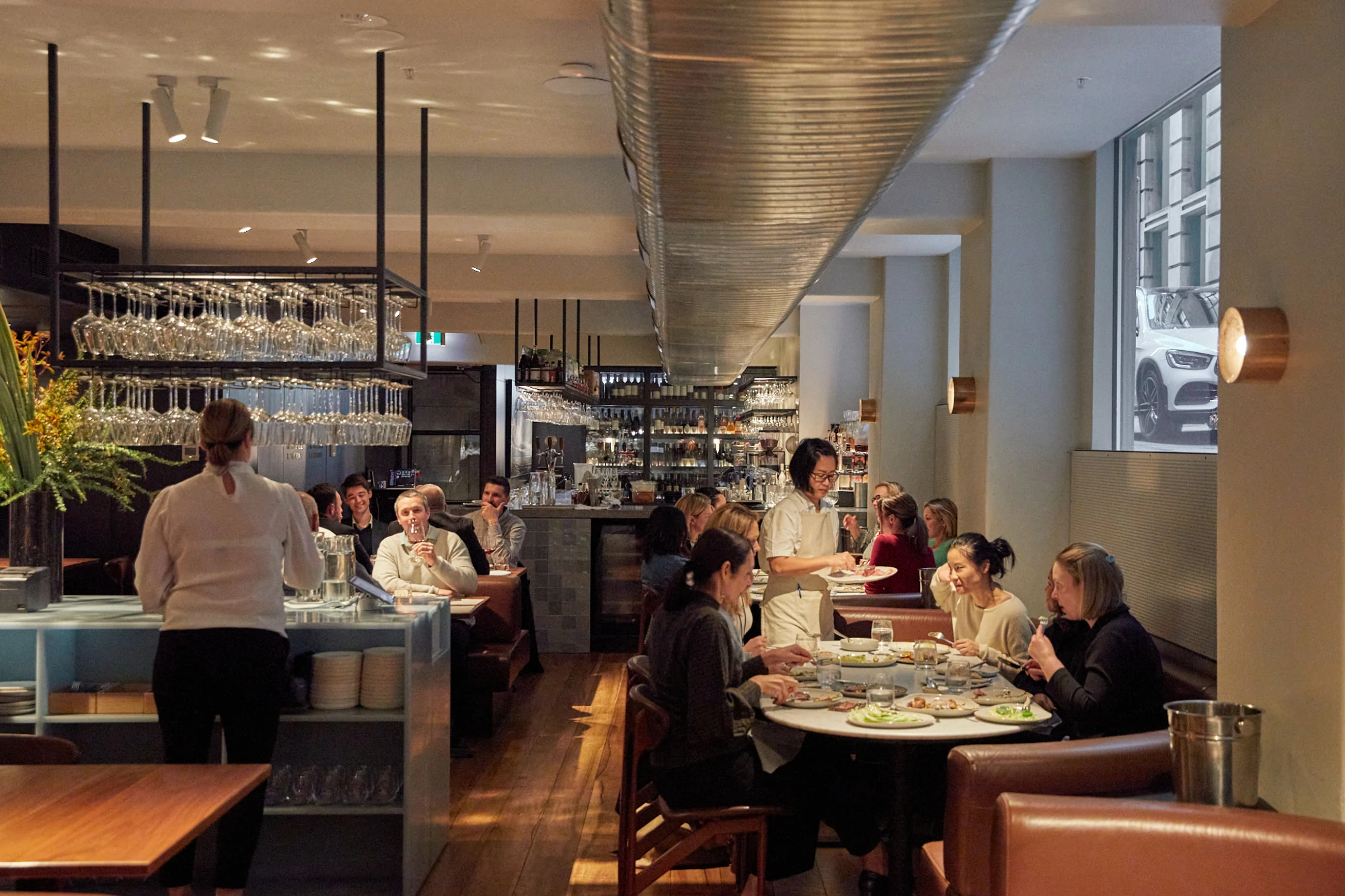 The interior of Nomad features white walls and warm brown leather benches