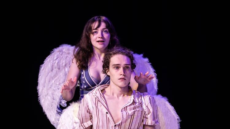 Two actors on stage, one with angel wings