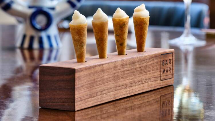 Four cones filled with foam sitting in a wooden block.