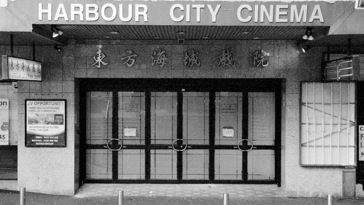 The front of the old and abandoned Harbour City Cinema in a black and white photo