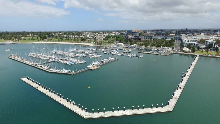 An aerial shot of a boomerang-shaped pier in Corio Bay.