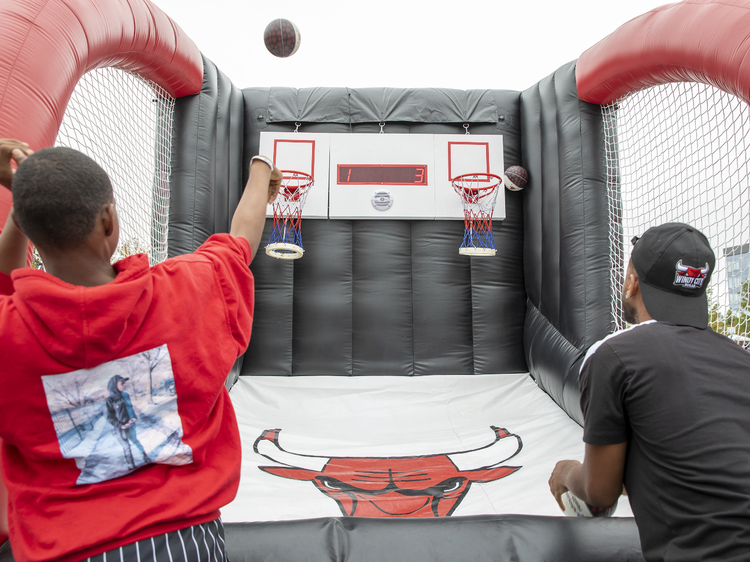 Two people play a game of carnival-style Bulls-themed basketball