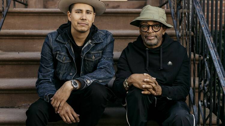 Kyle Bell and Spike Lee pose on a staircase.