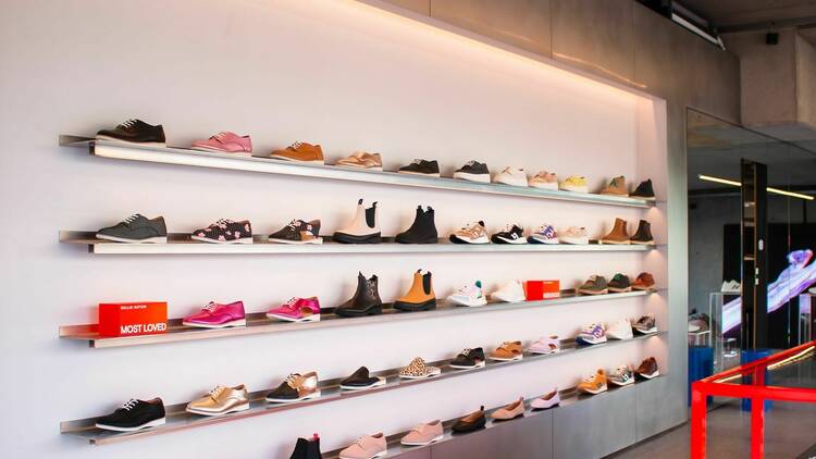 Shelves filled with shoes of various kinds in a store.