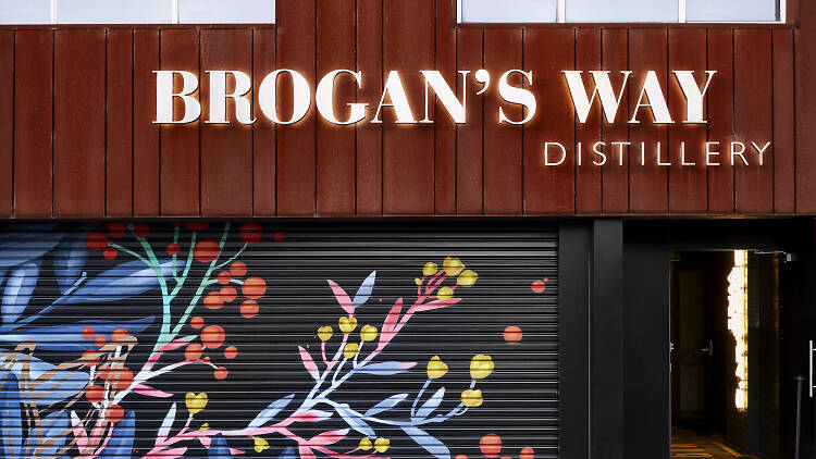 The Brogan's Way Distillery sign above a painted garage door