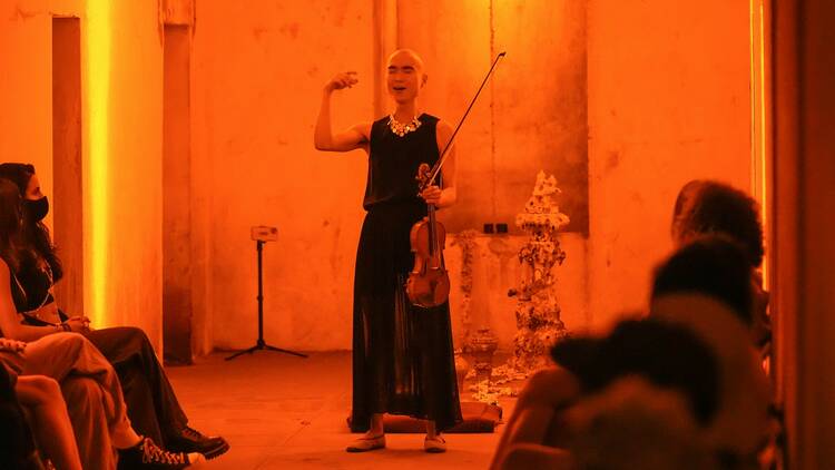 A performer with a violin in the catacombs at Green-Wood Cemetery.