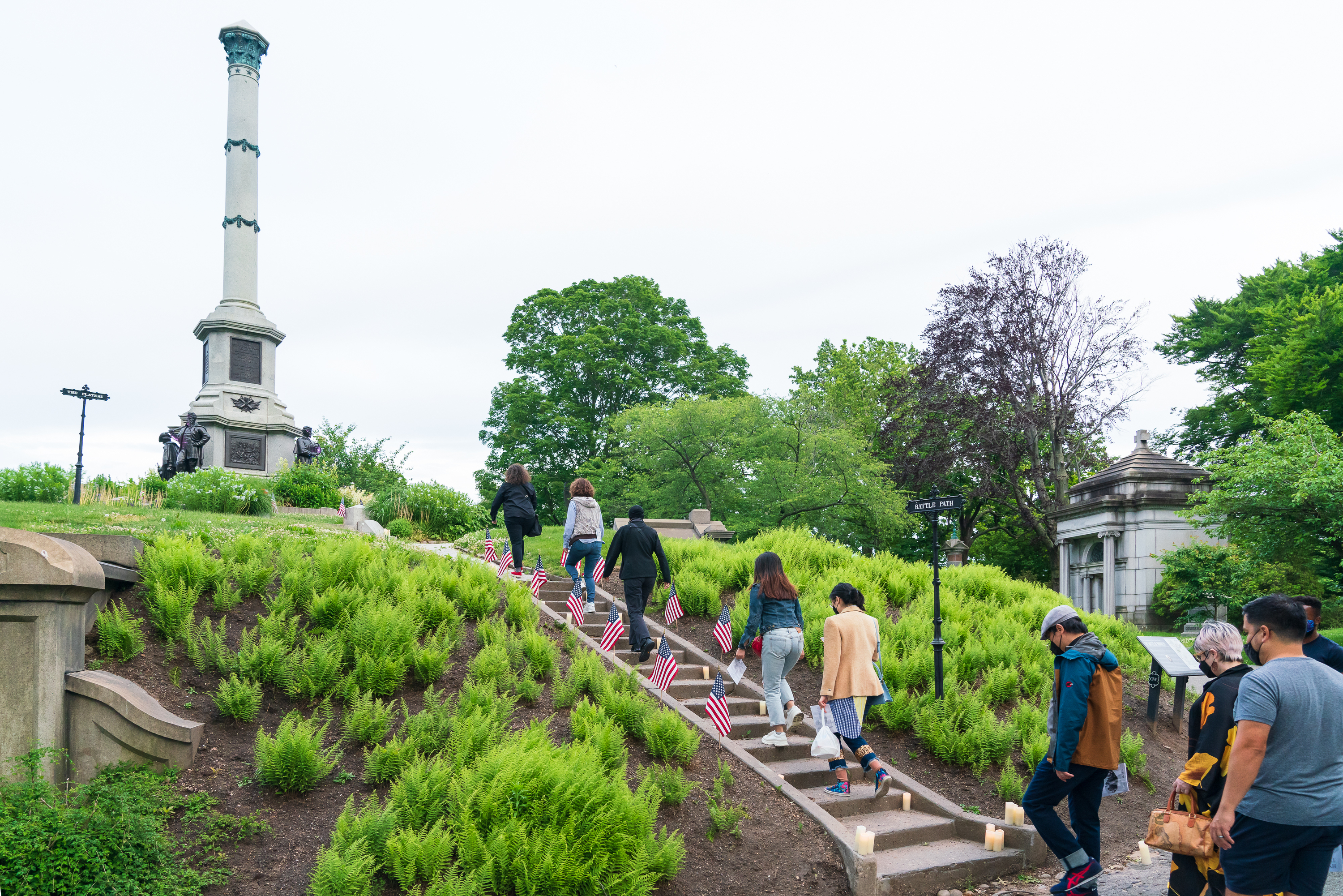 A group of people walks past grave markers.