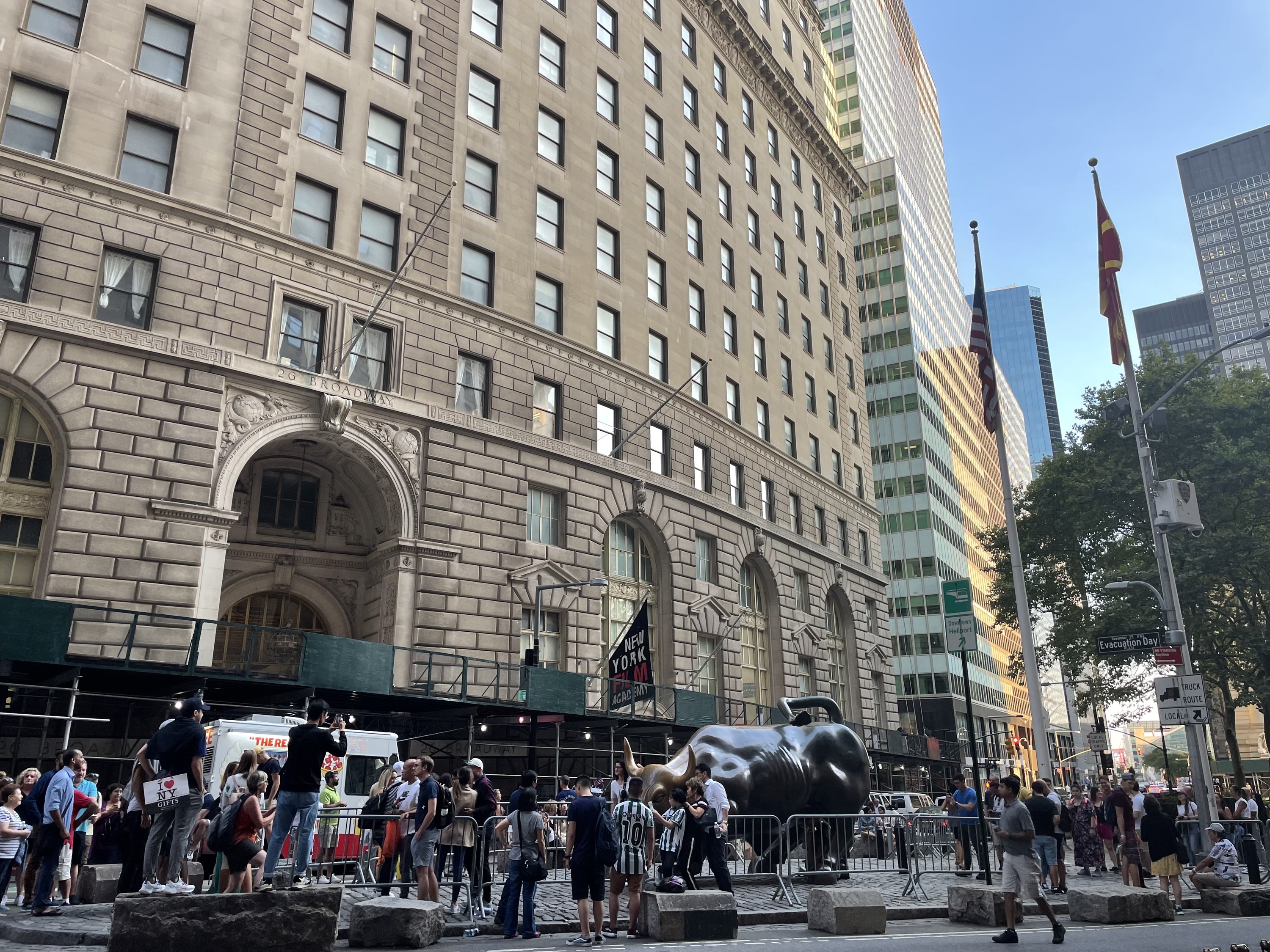 The Wall Street bull with a line of people.