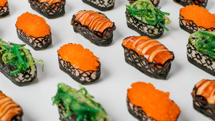 Sushi filled with seaweed salad and roe with custom design etched into the seaweed