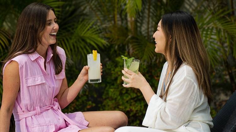 Photo of two girls enjoying cocktails
