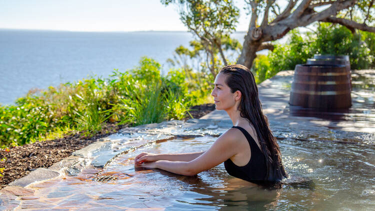 A woman relaxing in an outdoor hot spring.