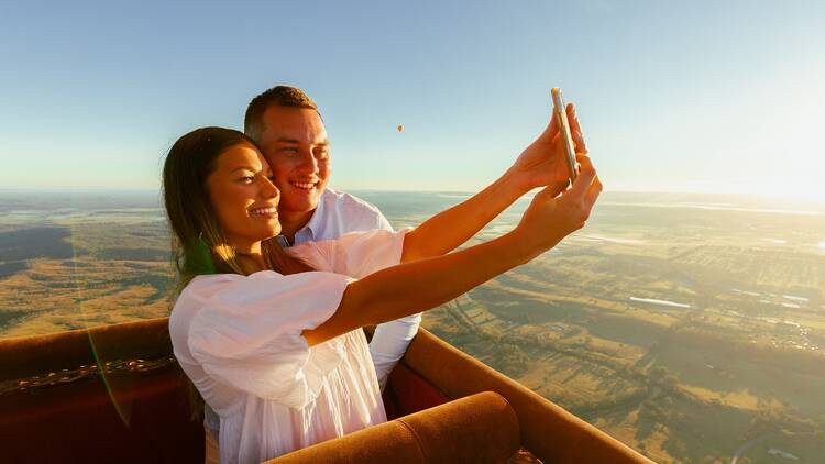 A couple taking a selfie on a hot air balloon