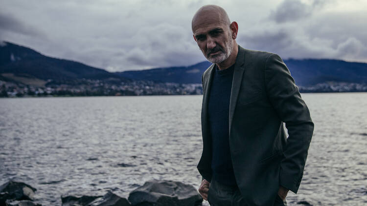 Paul Kelly stands in front of the ocean