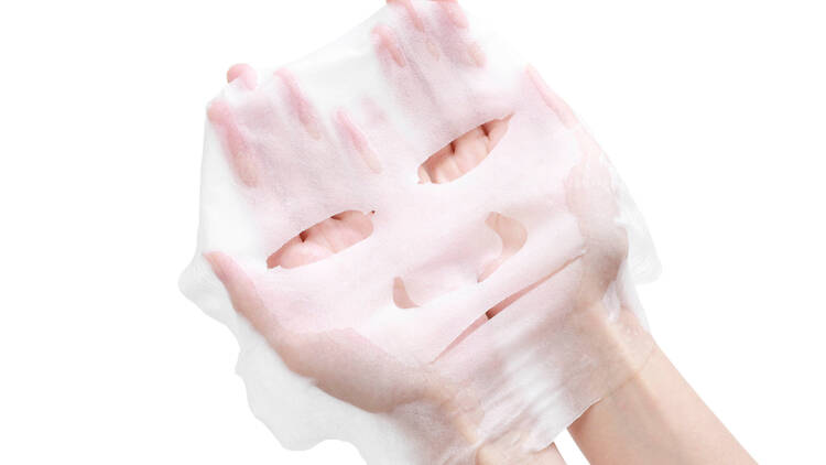 Hands holding a sheet mask. 