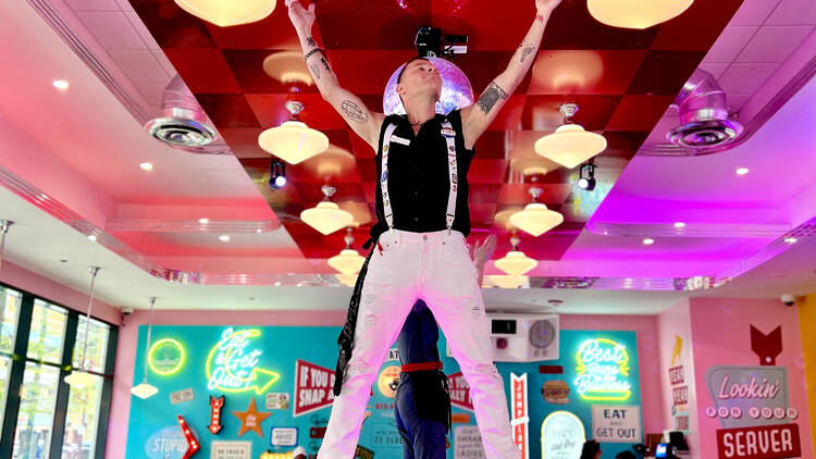 A server with his hands raised on a restaurant counter.