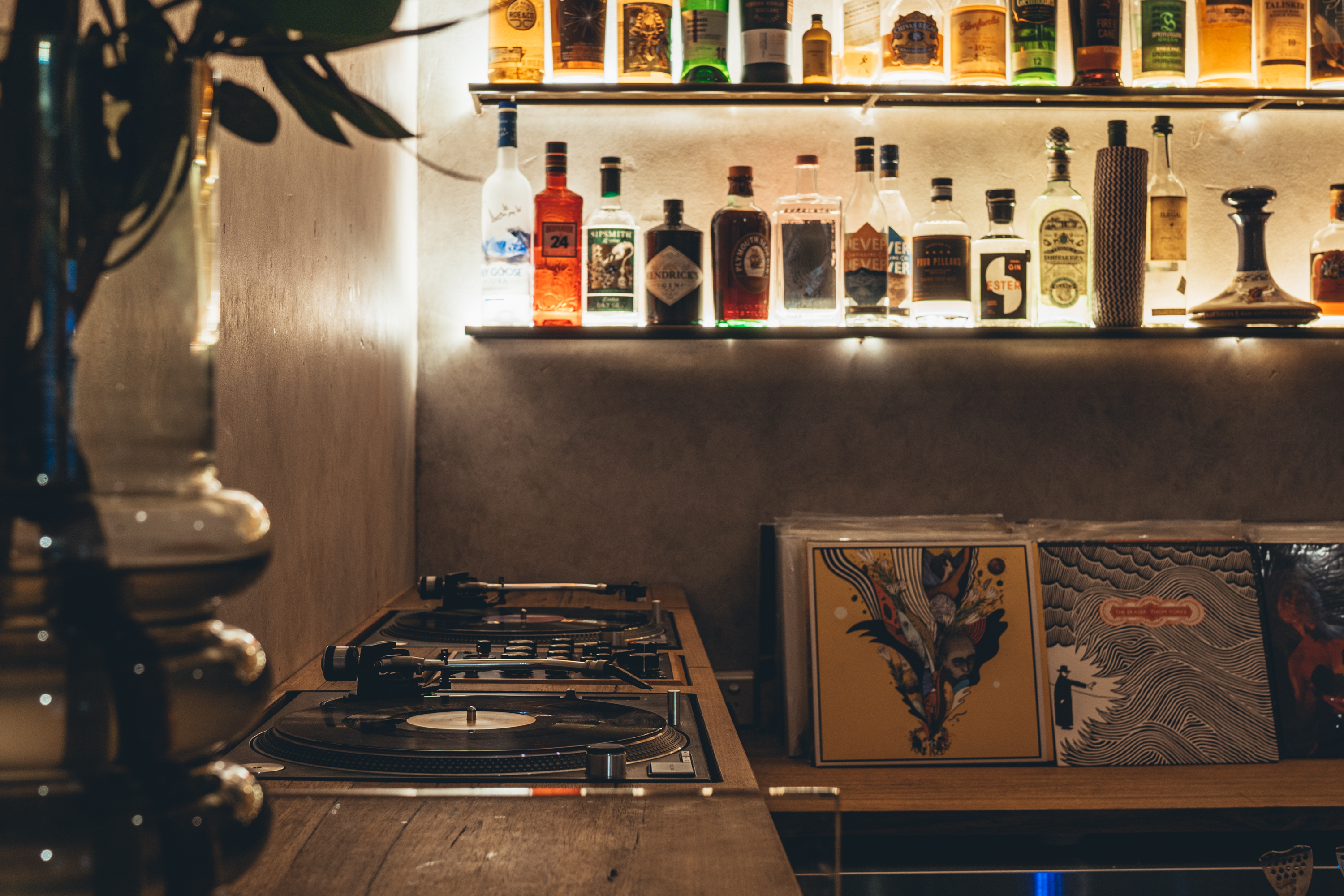 Behind the bar is a built-in backlit bar with a vinyl player, record collection and bottles