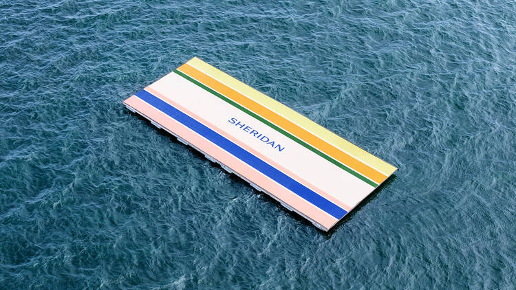 A giant multicoloured beach towel floats down Sydney Harbour