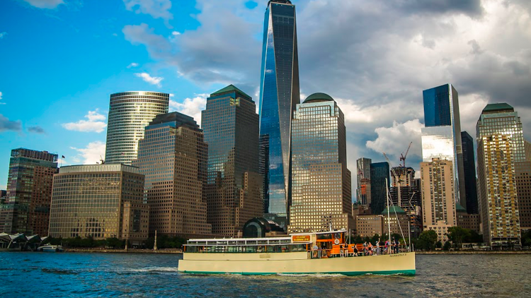 Classic Harbor Line boat in front of the NYC skyline.