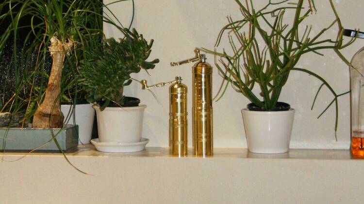 Gold decorations next to white vases with plants.