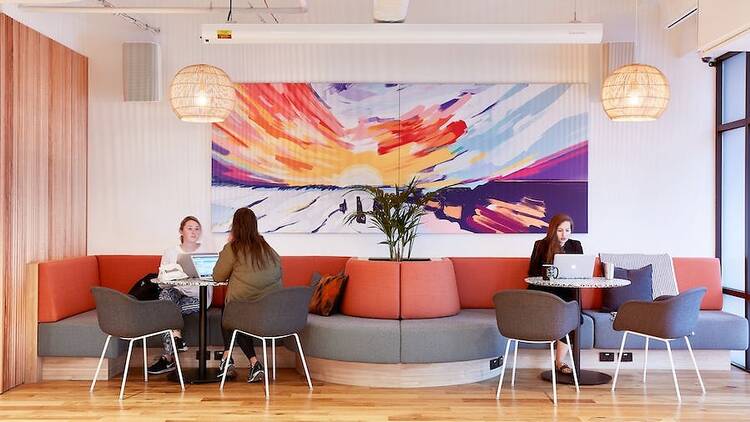 Three women working in a WeWork co-working space.