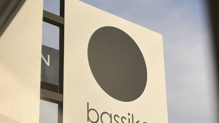 The sign outside the Bassike store which has a black circle and the word bassike written underneath