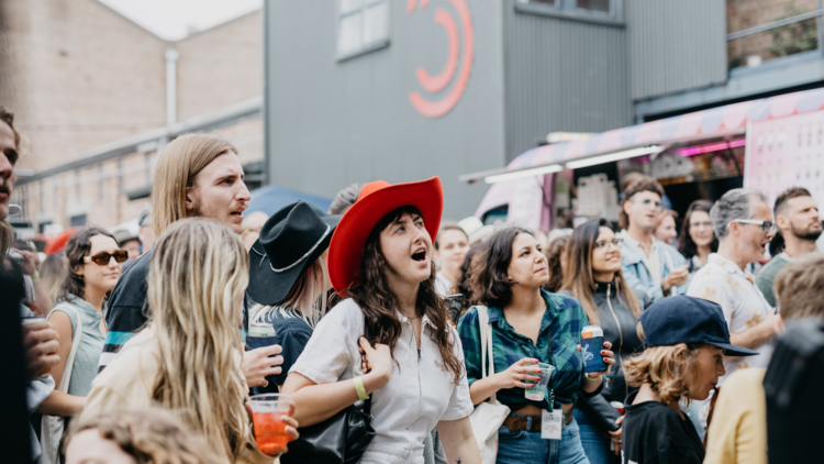 People sing in the front row of a mosh pit outside 