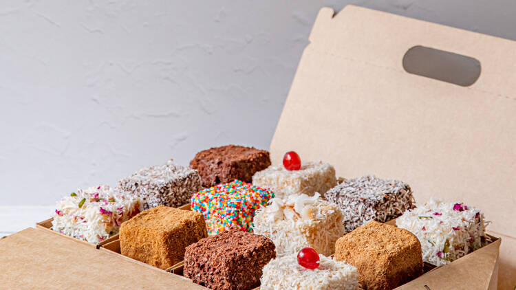 A cardboard box filled with a selection of lamingtons of different flavours