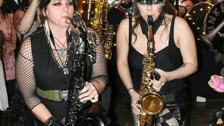 Two members of the Funkrust Brass Band play saxophones.