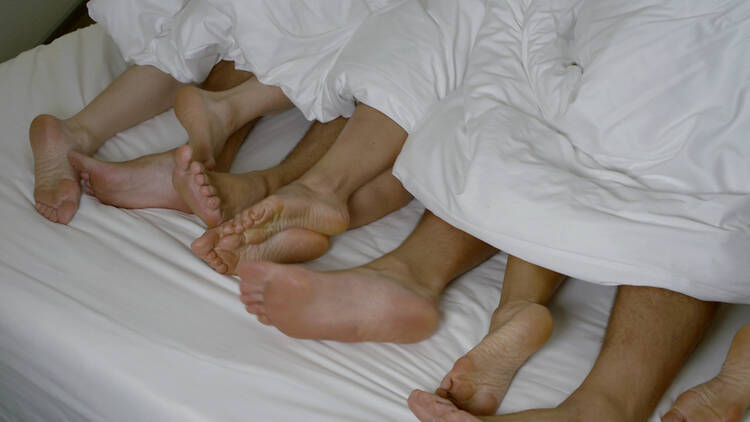 A group of three people under the sheets.