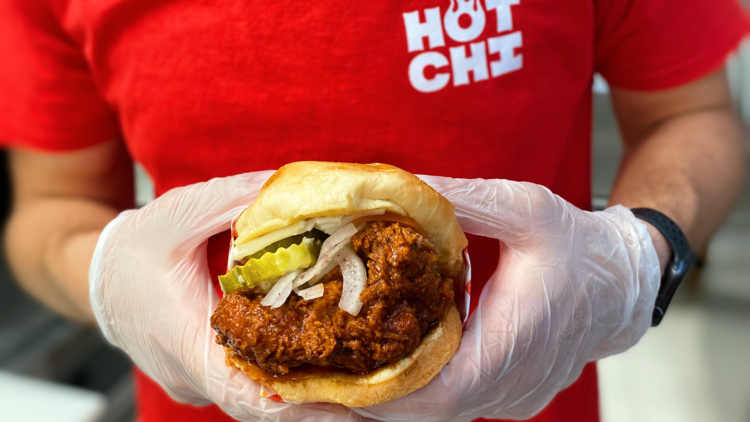 A person holding a fried chicken sandwich.