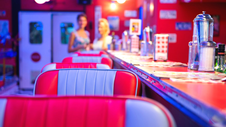 A row of red leather bar stools in a 50s diner