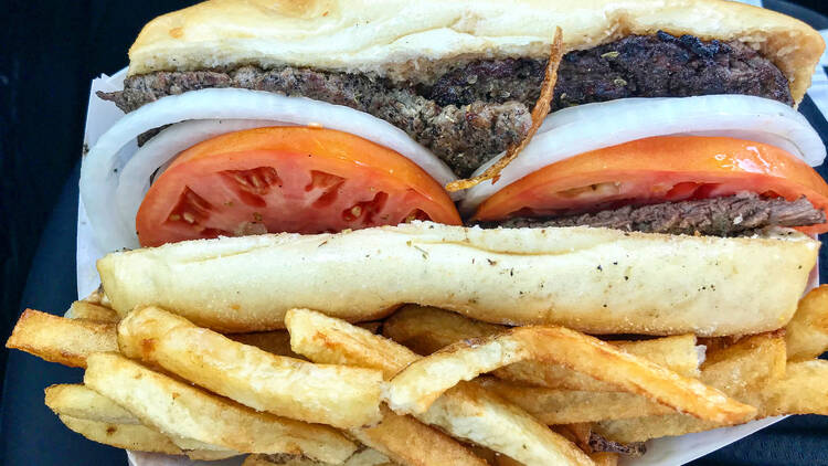 A steak sandwich with fries.