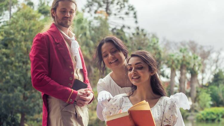 Two women and a man in English Regency dress