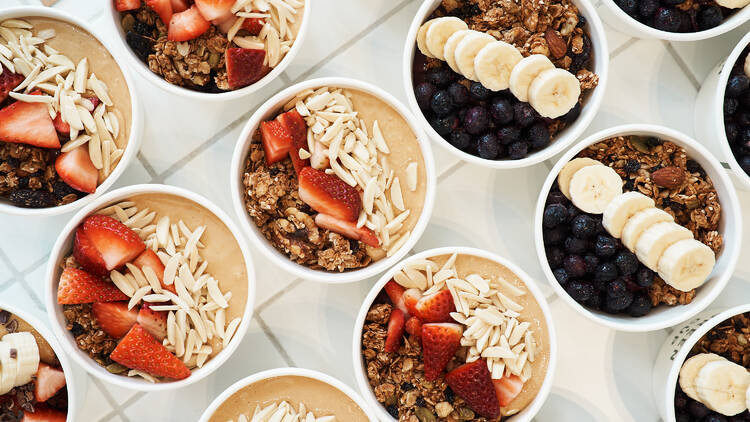 An overhead view of several acai smoothie bowls.