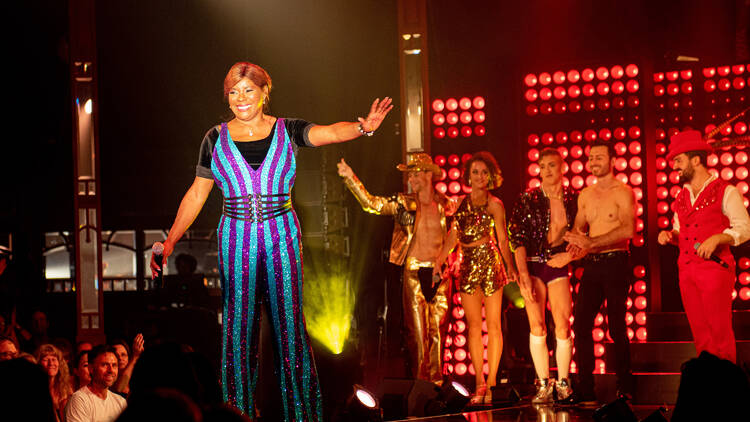 Marcia on stage in a fantastic blue and purple jumpsuit 