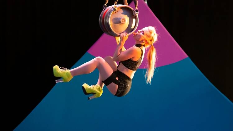 An acrobat hanging from a pendulum 