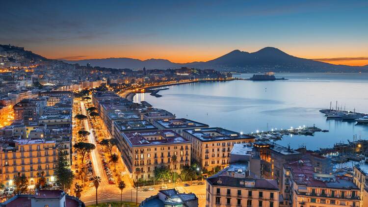 Naples, Italy aerial skyline on the bay with Mt. Vesuvius at dawn.