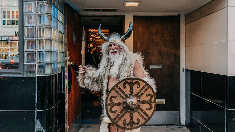 A man dressed as a viking poses in front of Simon’s Tavern