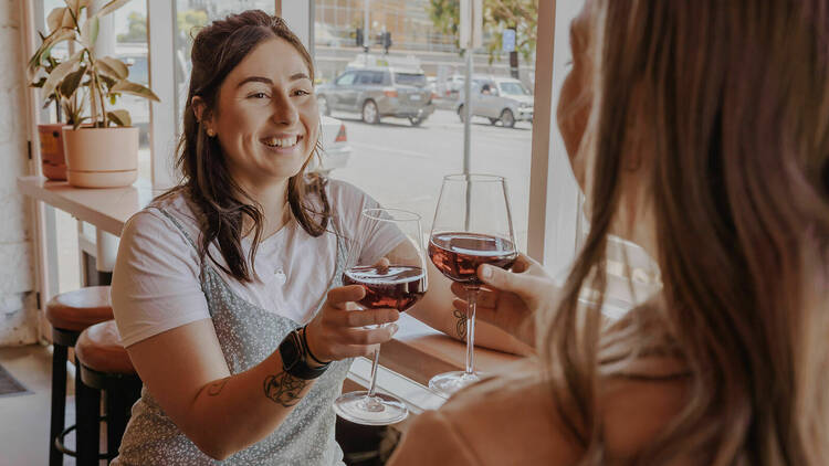 Two women cheersing with glasses of red wine at Ragazzone.