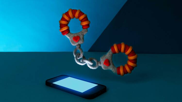 Hand cuffs floating over a lit up smart phone