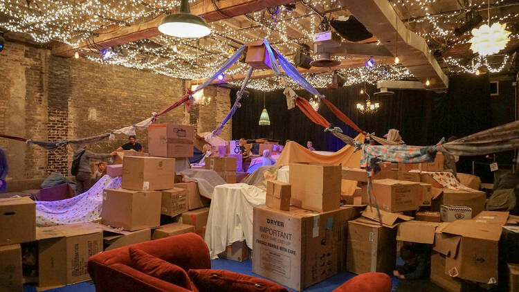 A series of cardboard boxes and sheets make forts